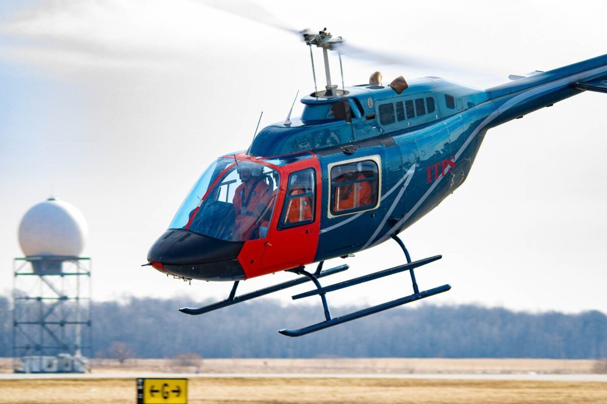 Bell 206 helicopter hovering above ground