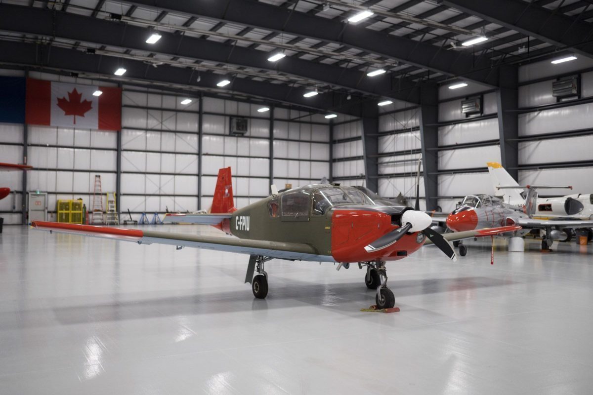 Green and red Brassov airplane in hangar.
