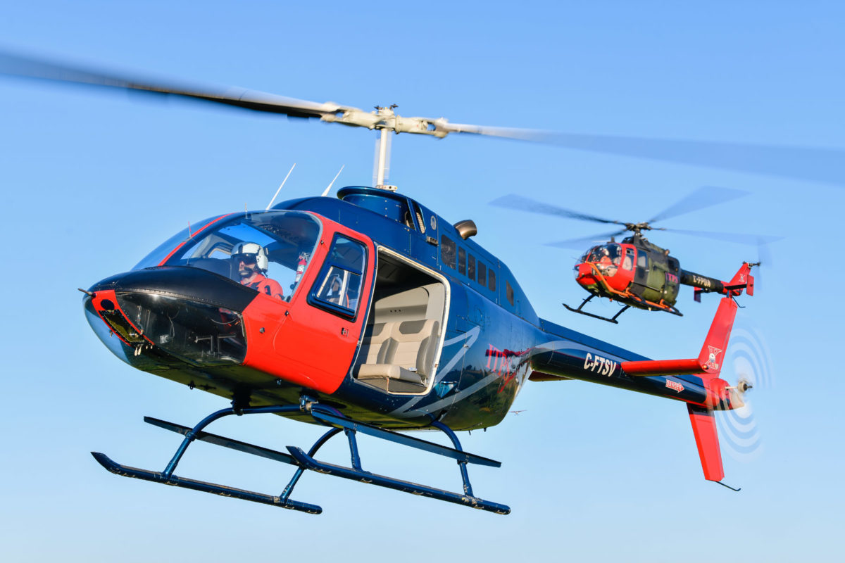 Blue and red Bell B106 helicopter and green and red MBB Bo106 helicopter
