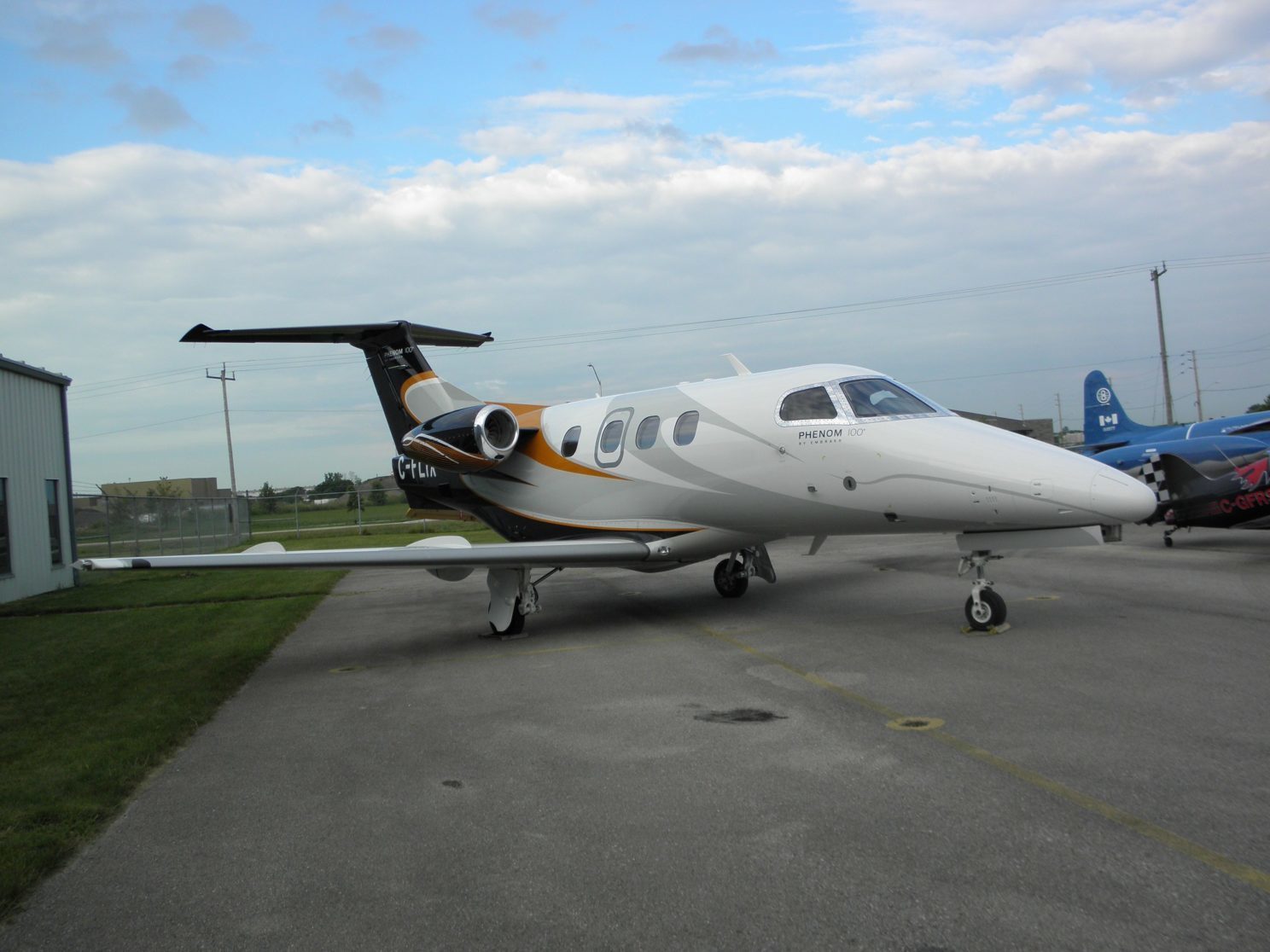 Black and white Embraer Phenom 100 aircraft at ITPS Canada