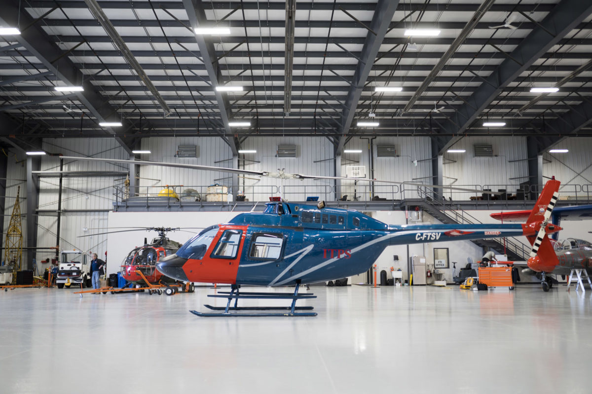 Blue and red Bell B106 helicopter in the hangar