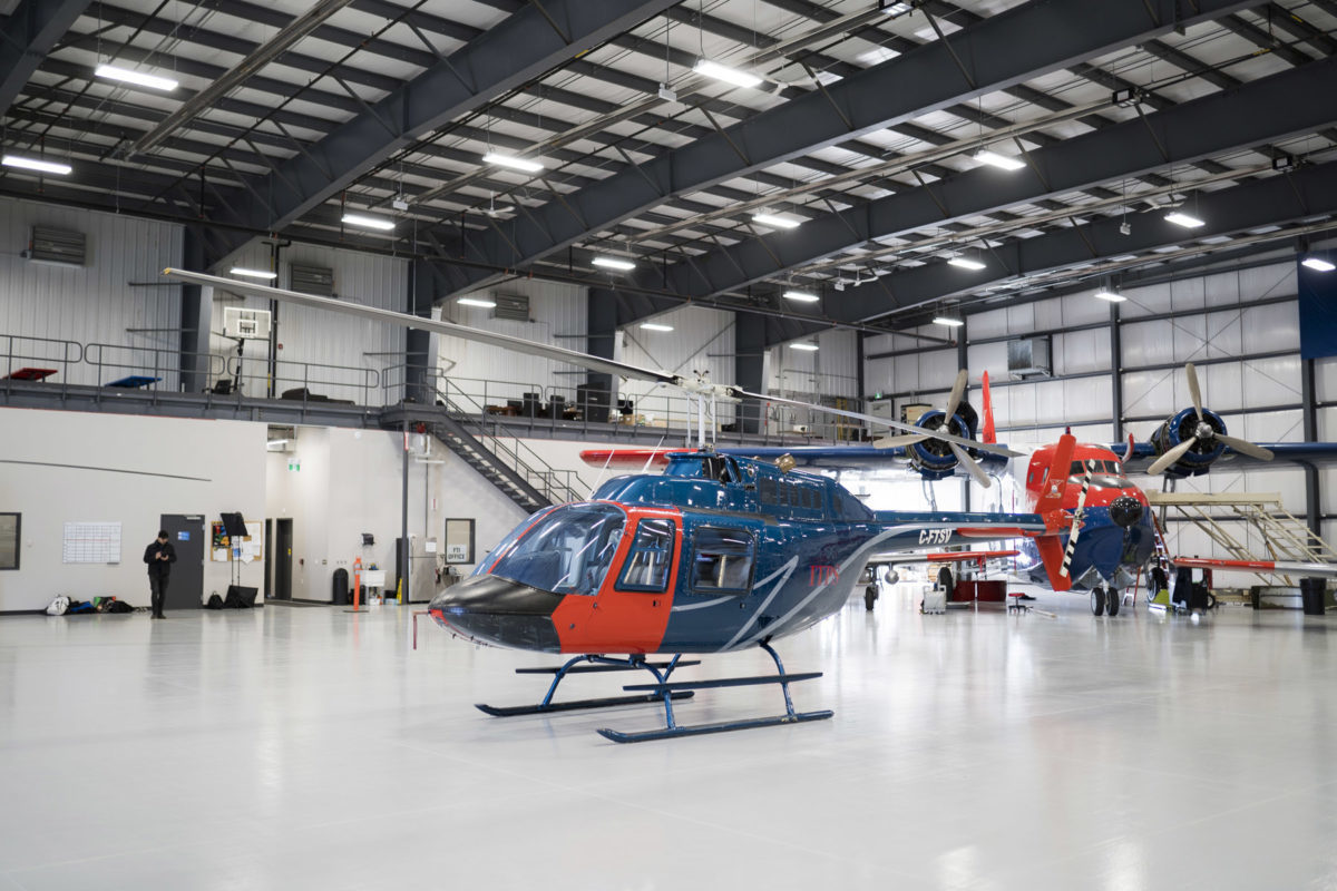 Blue and red Bell B106 helicopter in hangar