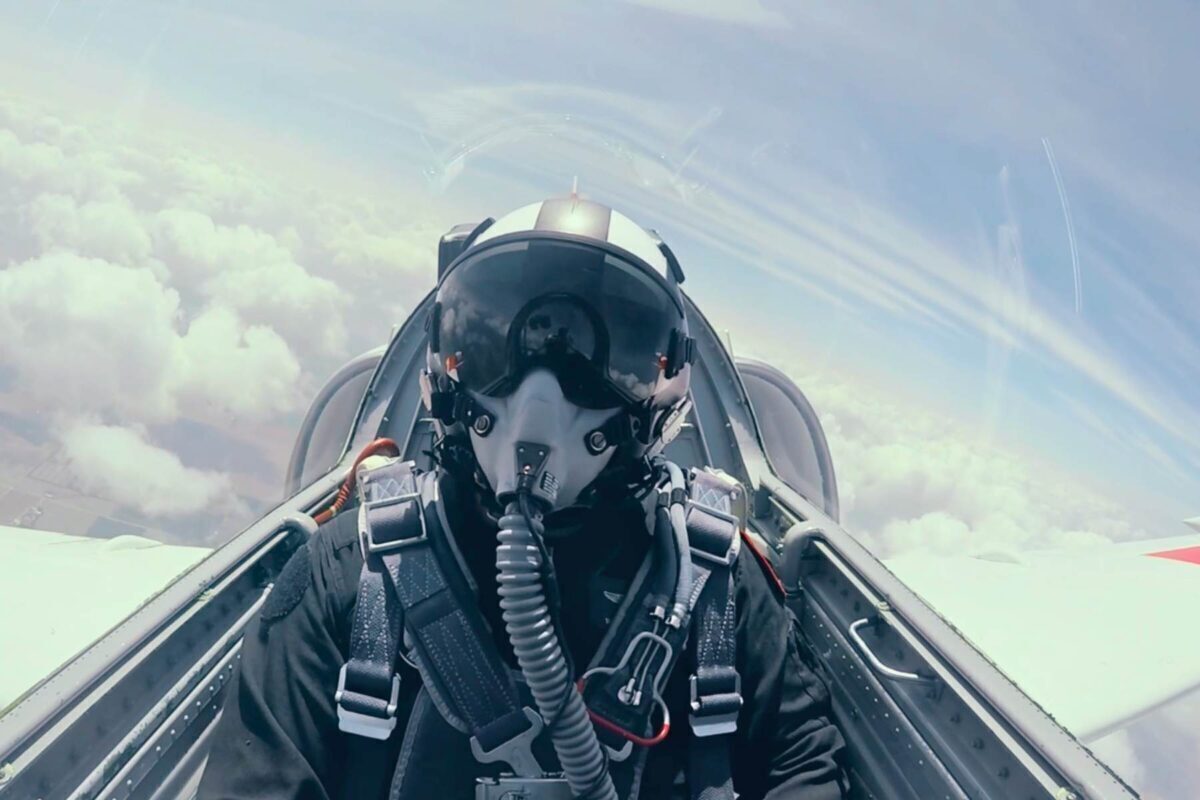 pilot with mask and oxygen in l39 cockpit above clouds