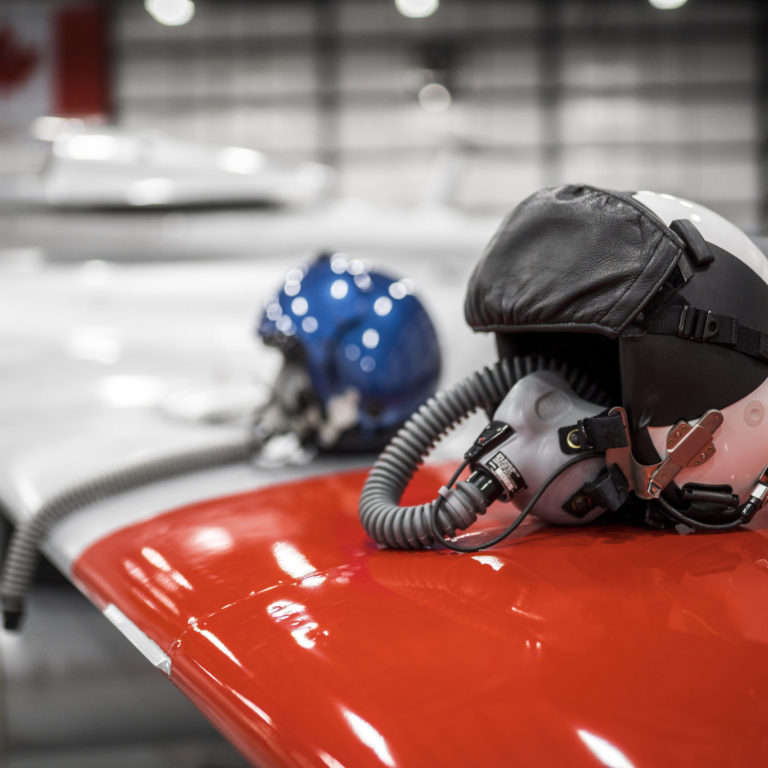 ITPS personnel helmets rest on a red and white striped wing of an aircraft in the hangar.