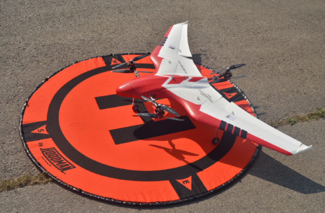 Red and white unmanned aerial system sitting in a target.