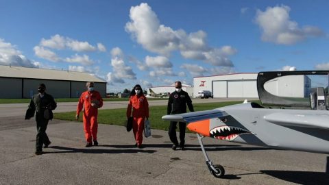 Students and flight test instructors with grey and orange manned remote piloted aircraft
