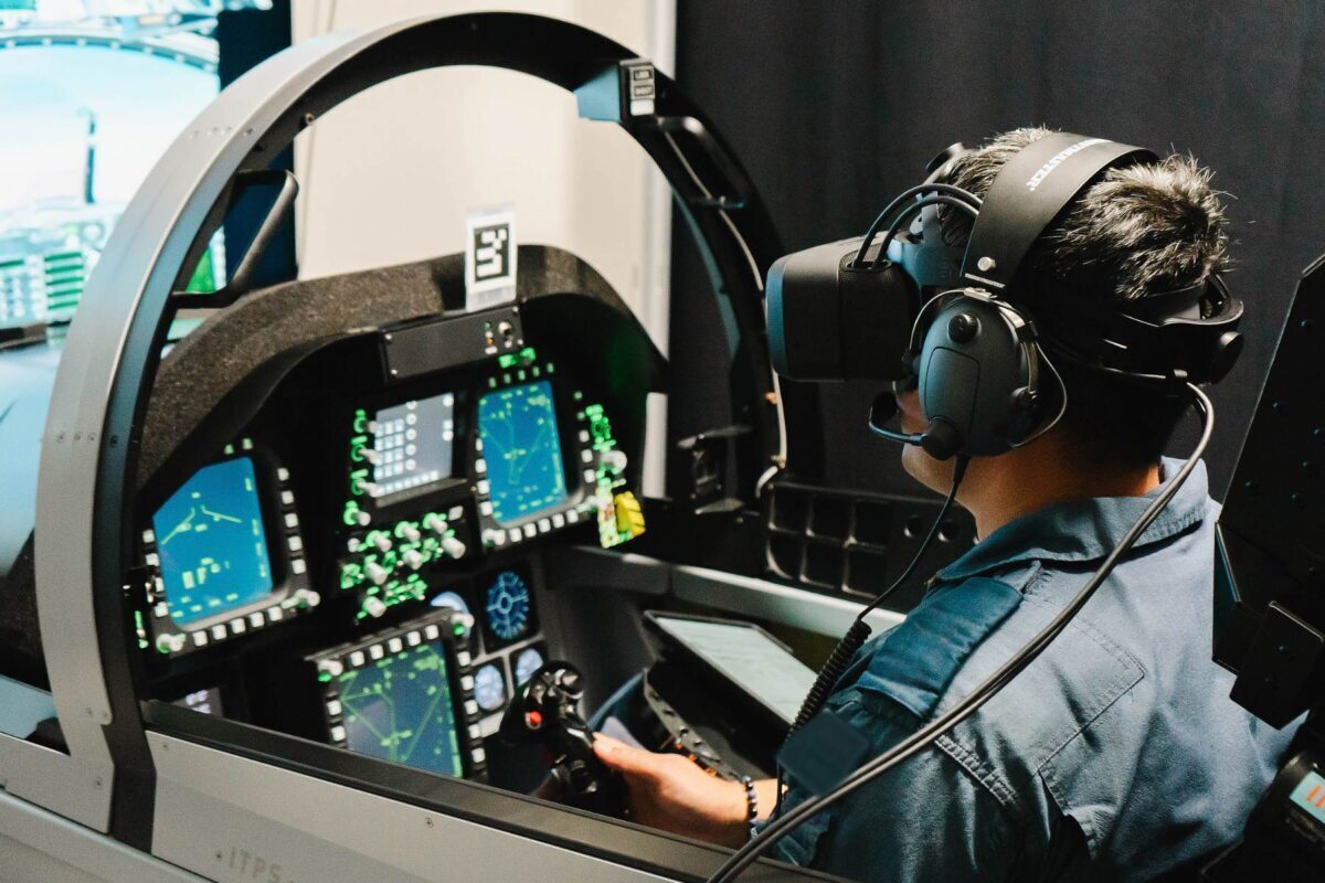 student wearing mixed reality headset in F18 cockpit simulator