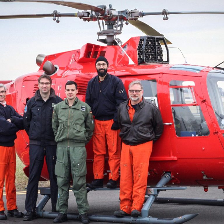 flight test instructors and students beside red helicopter Bo 105