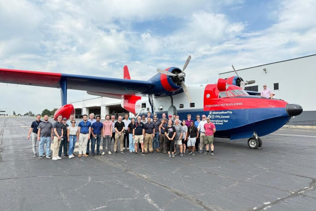 1 group of people standing in front of Grumman HU-16 Albatross