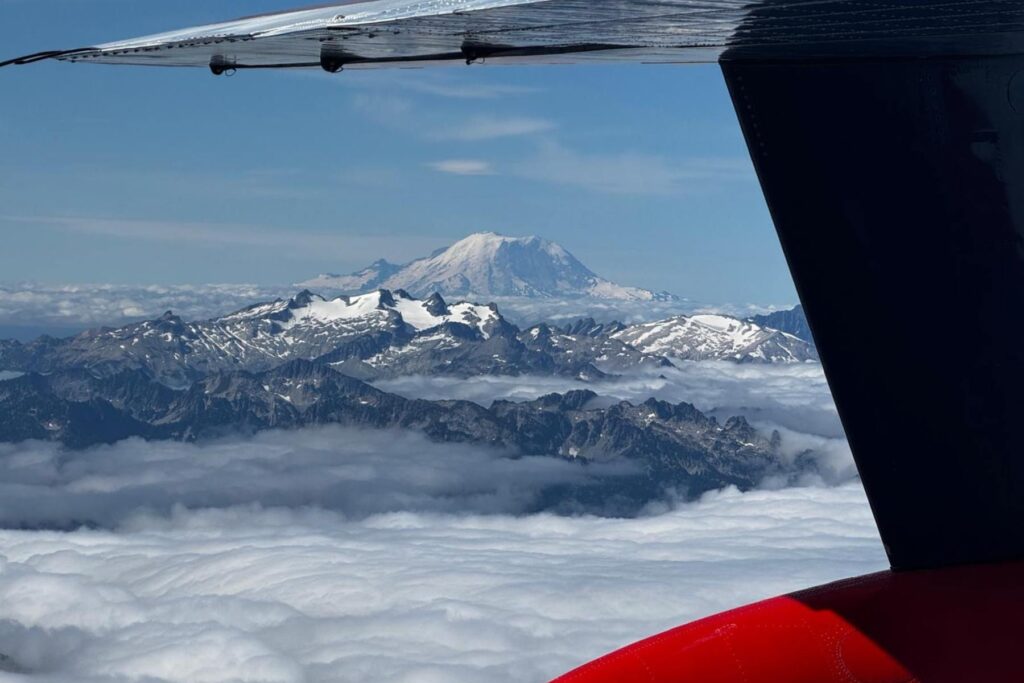 1 plane above clouds looking over mountain horizon