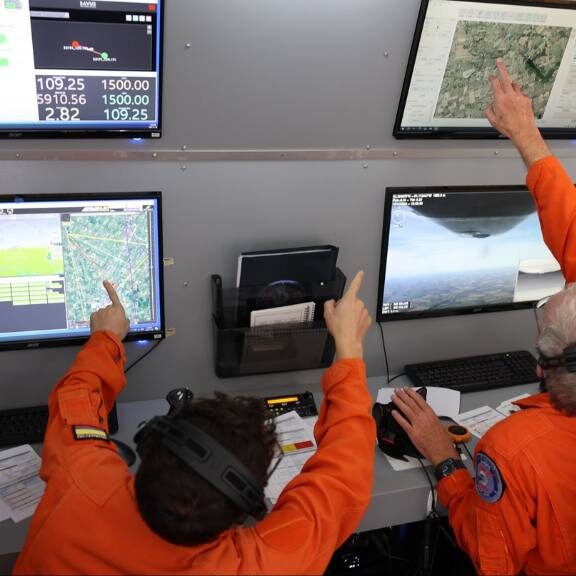 two UAS instructors pointing to screens