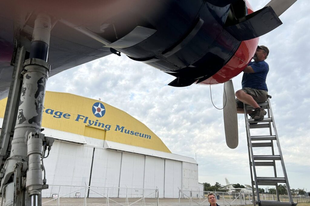5 Todd Polcher working on HU-16 propeller in front of Vintage Flying Museum hangar