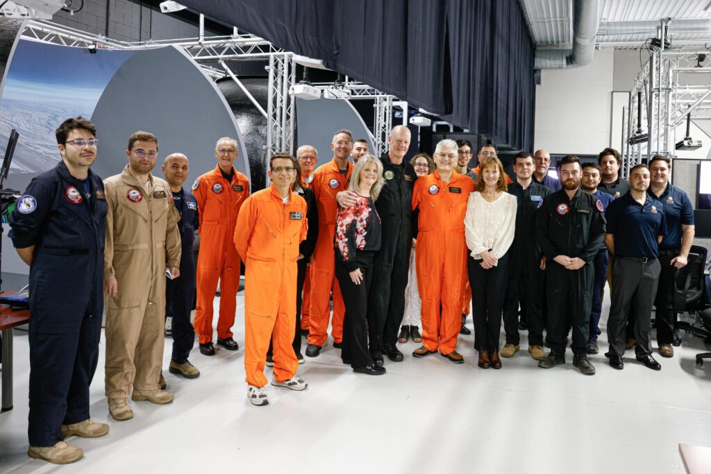 2 large group of ITPS team members stand together in Advanced Aircraft Simulation Centre