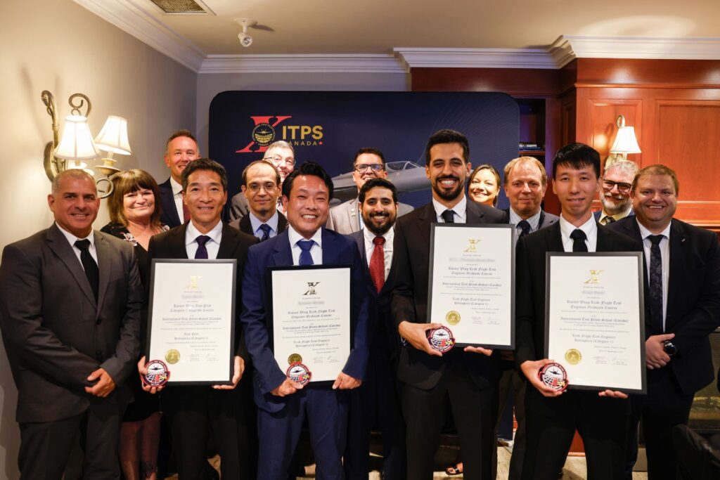 yes ITPS Graduates stand holding plaques with ITPS instructors