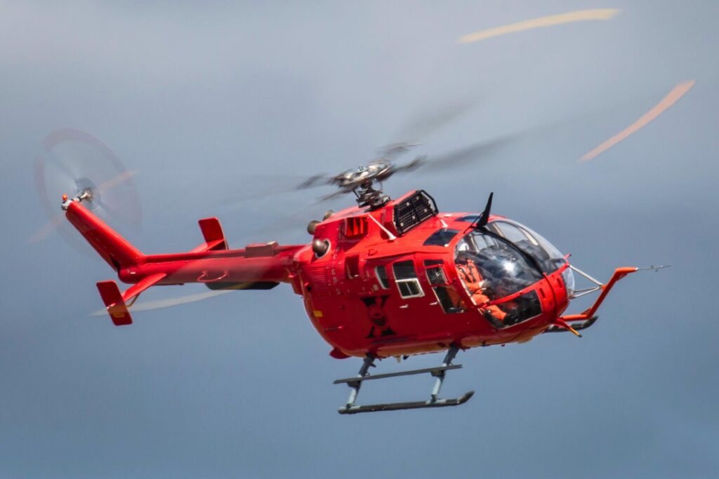 yes (5) Red Bo105 helicopter flying