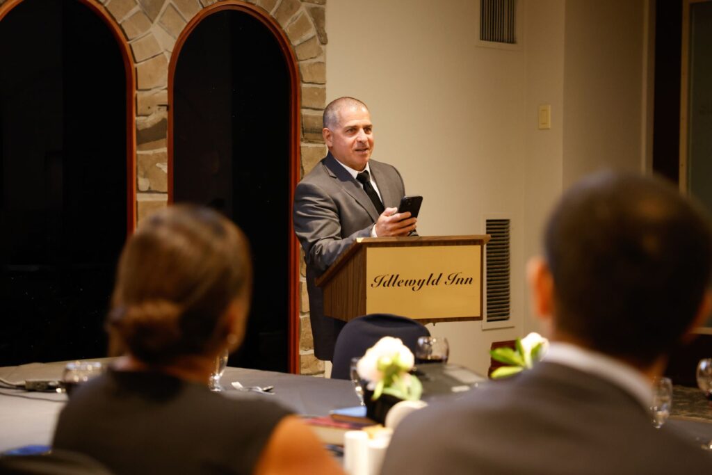 yes (7) ITPS instructor at podium addressing graduation audience