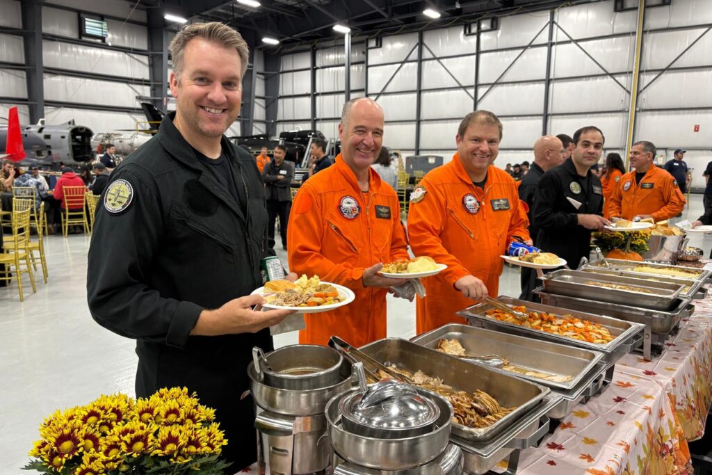 1 ITPS instructors grabbing food from thanksgiving buffet in hangar