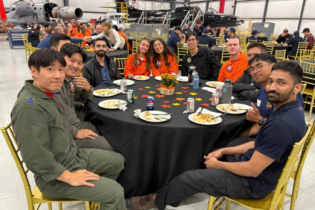 4 ITPS Students seated together at round table for thanksgiving lunch