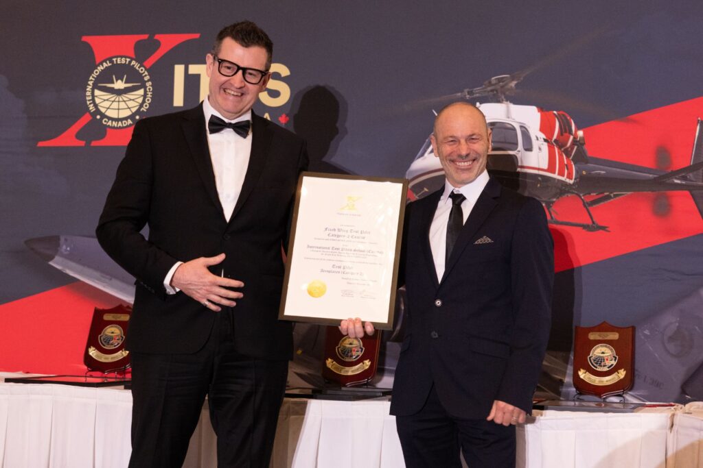 ITPS Fixed Wing Chief Instructor holding plaque with graduating student