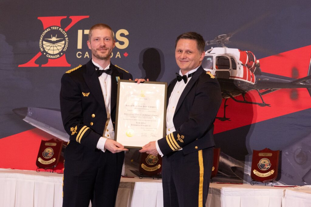 ITPS graduates holding plaques during ceremony