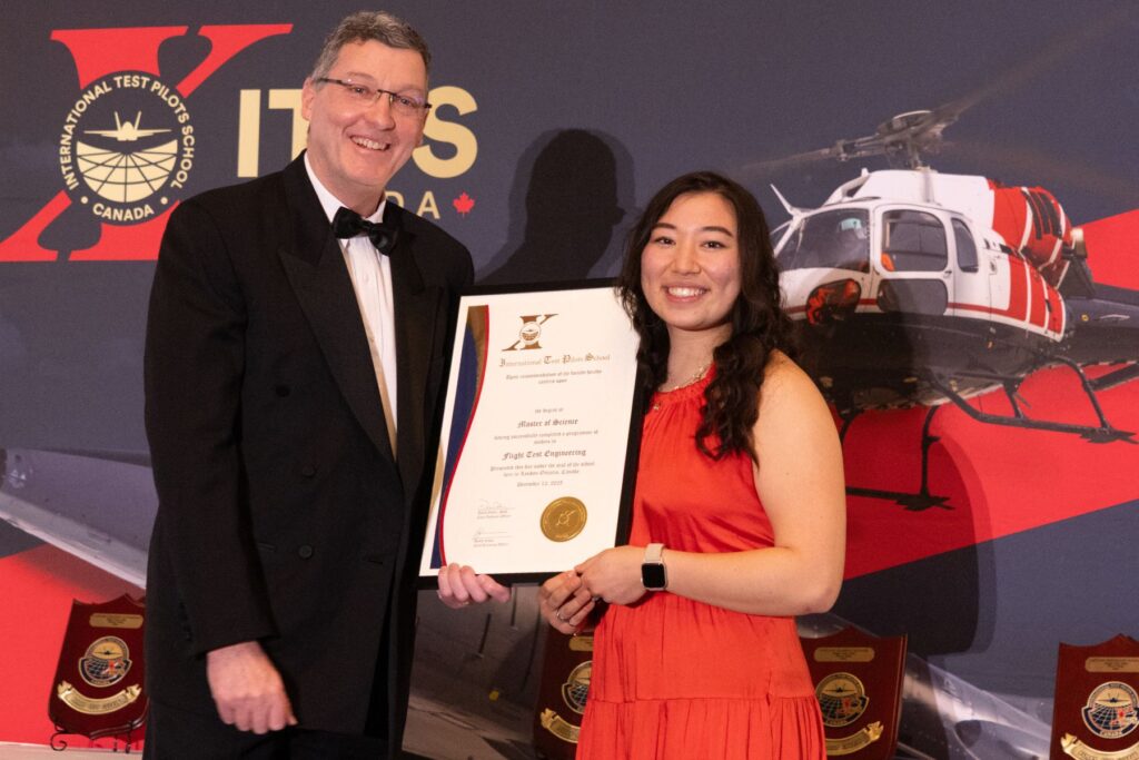David 'Dos' Ostler holding plaque with ITPS graduate Makenna Kuzyk
