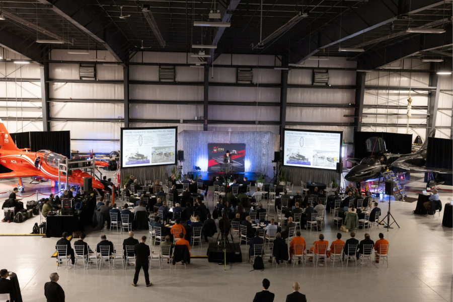2 crowd of attendees seated in aircraft hanger for ITPS seminar
