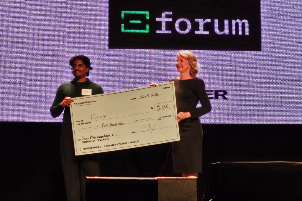 5 two people on stage holding large novely cheque at TechAlliance Polaris Pitchfest