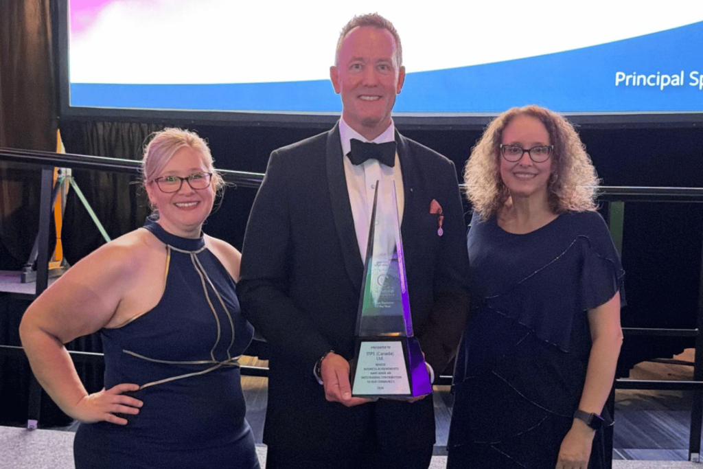 Dave Lohse, Megan Vanderwater, and Sheila Hodgson standing together holding trophy
