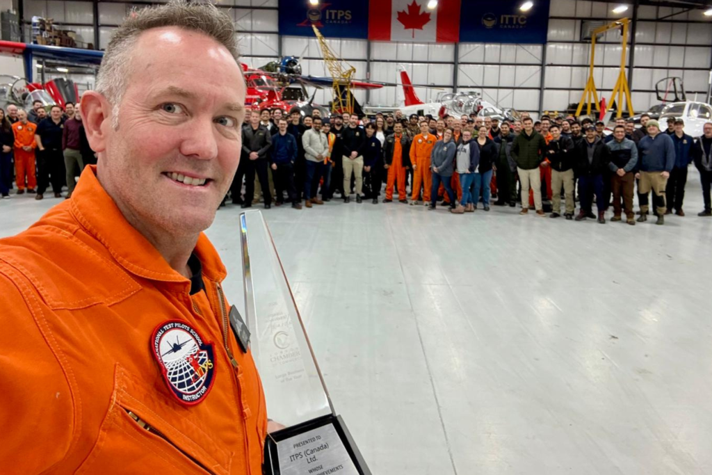 Dave Lohse, CEO of ITPS, taking selfie while holding London Chamber of Commerce Business Awards trophy with employees in the background