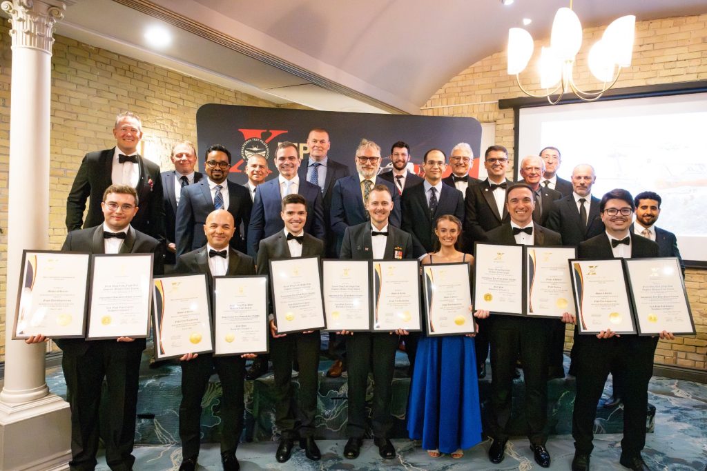 1781829987088 graduates stand together holding plaques with ITPS instructors