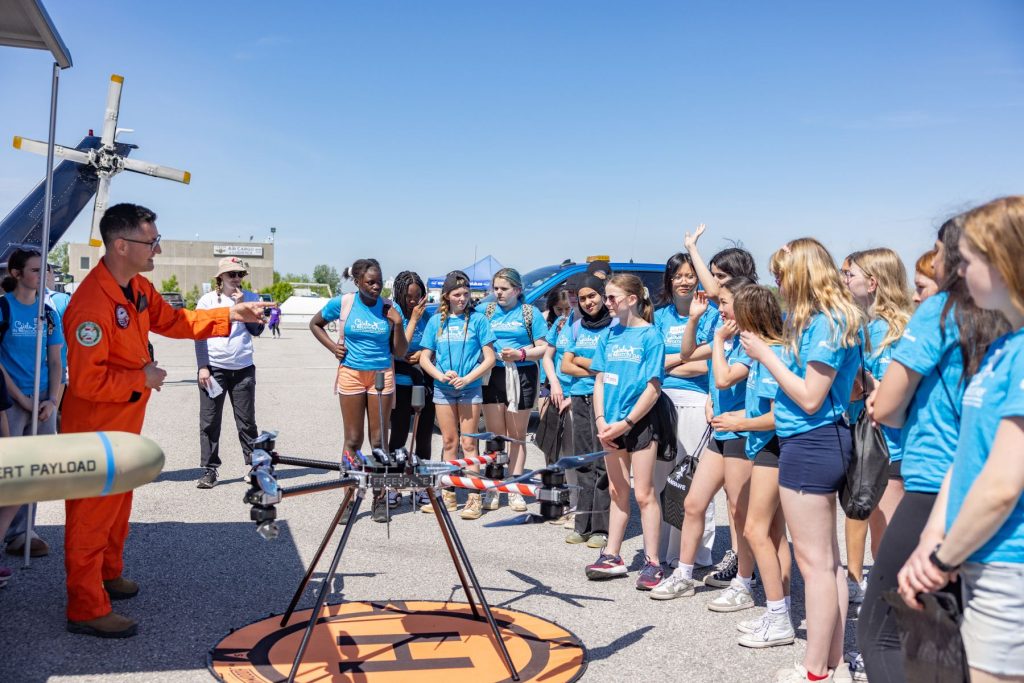 girls gathered around drone at ITPS on runway