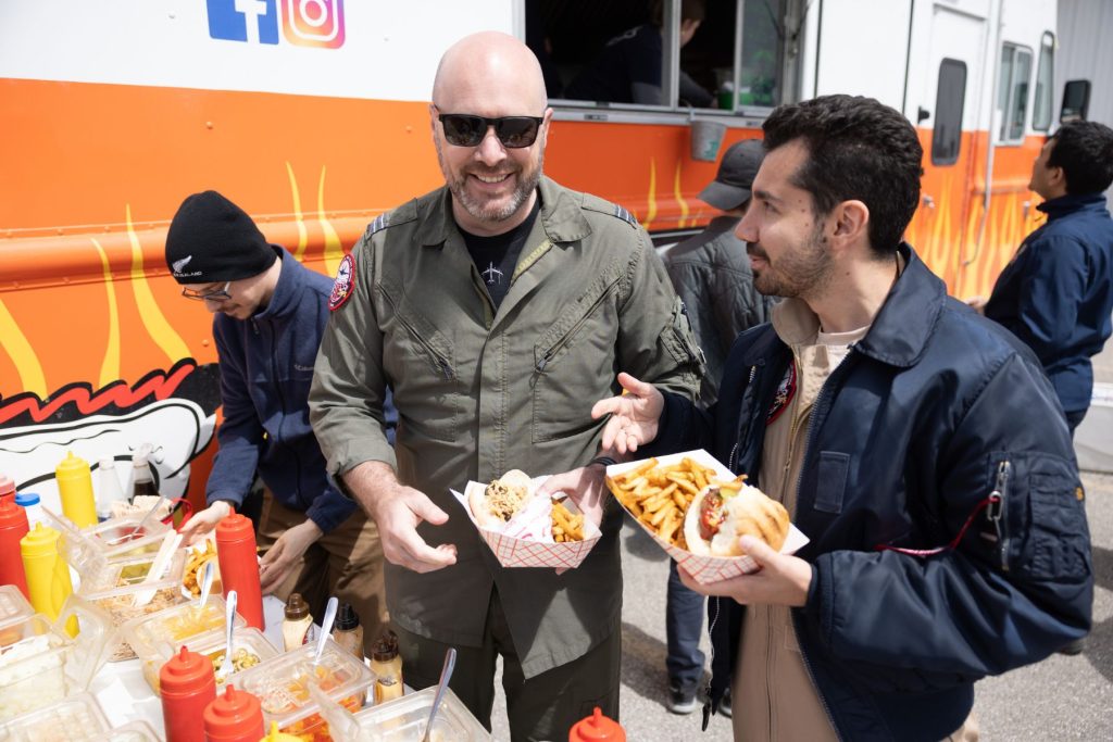 yes (5) ITPS students smiling as they gather food from food truck