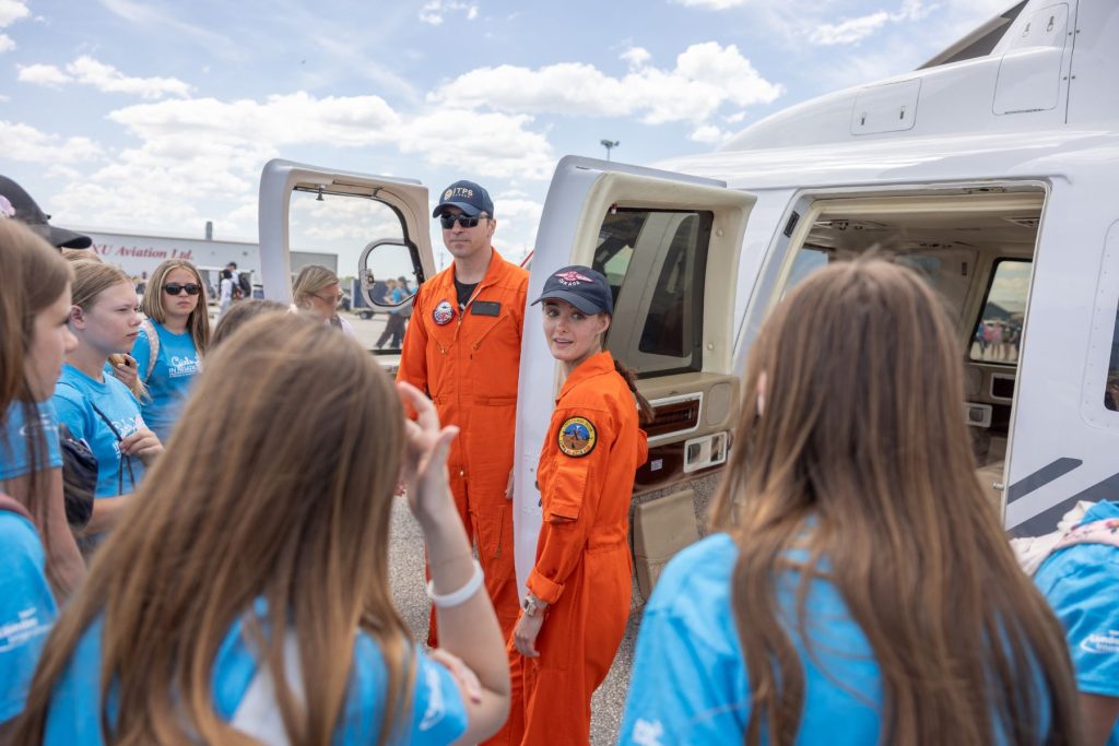 Two ITPS students beside S76 helicopter speaking to group of girls