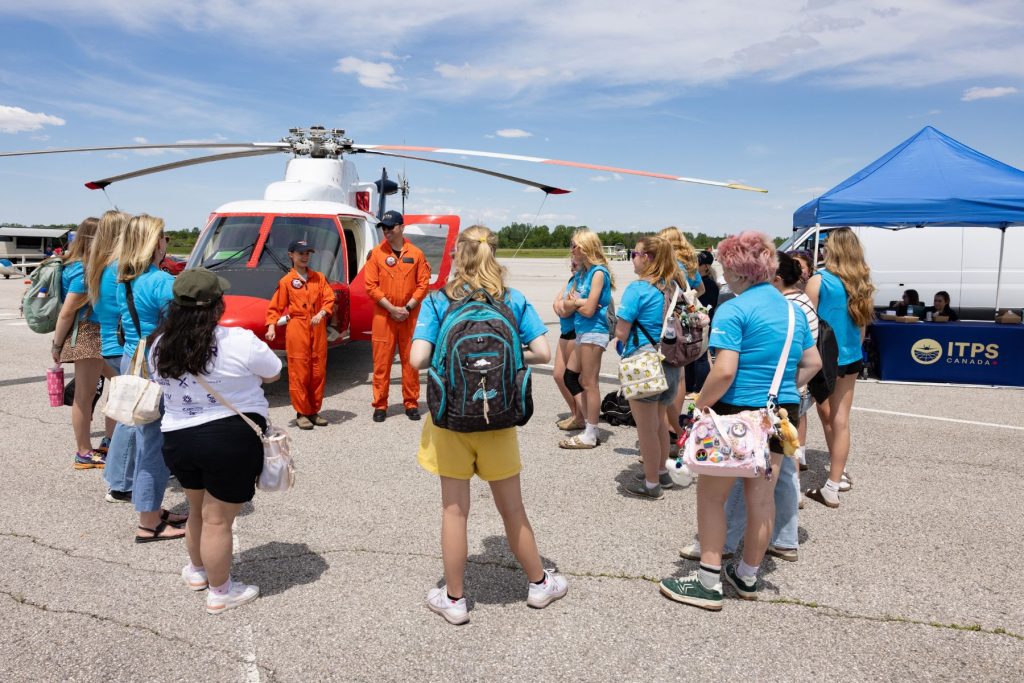 group of girls around S76 helicopter while ITPS students speak