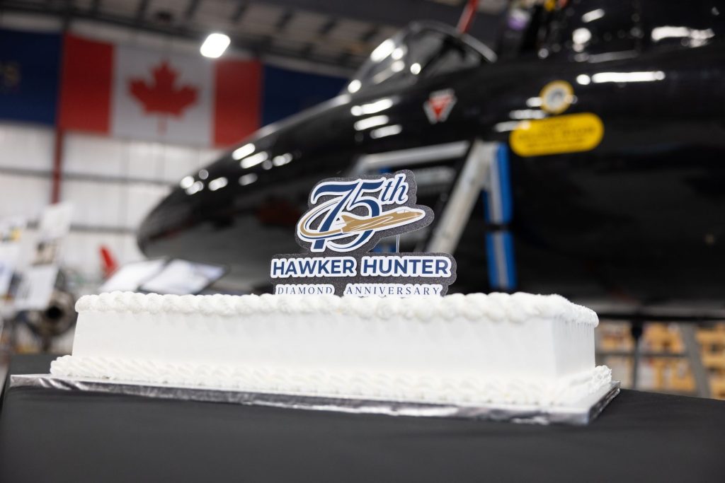 1 Decorative cake topper for 75th Hawker Hunter anniversary in front of Hunter jet