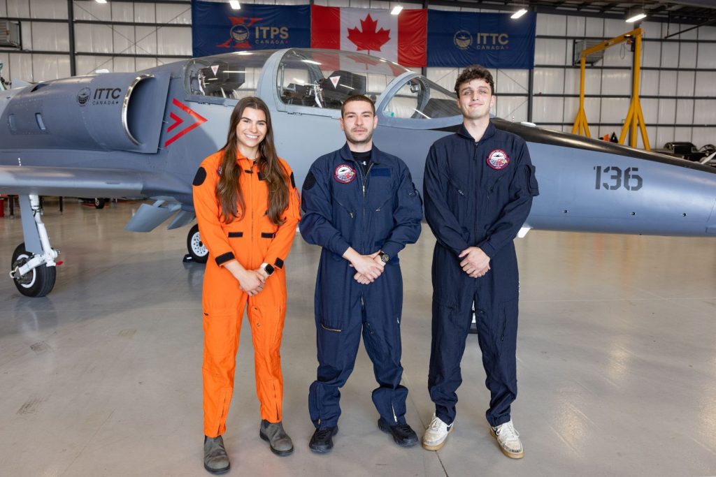 1783536390688 three ITPS flight test students in front of grey L39 jet in hangar
