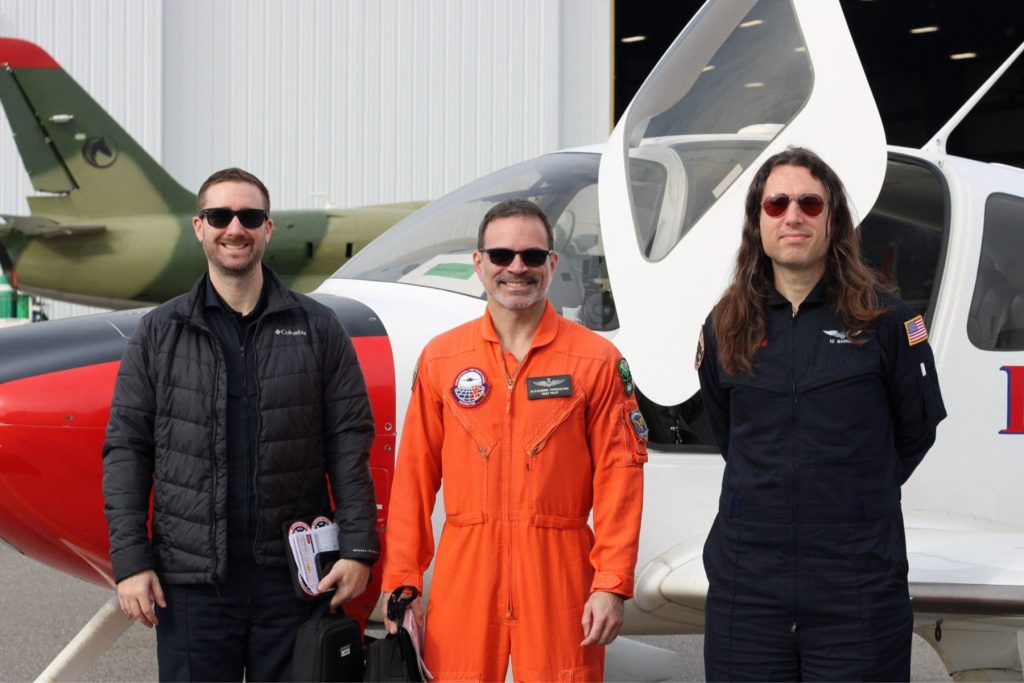 9 Honeywell Aerospace students with ITPS instructor in front of fixed wing aircraft at ITPS