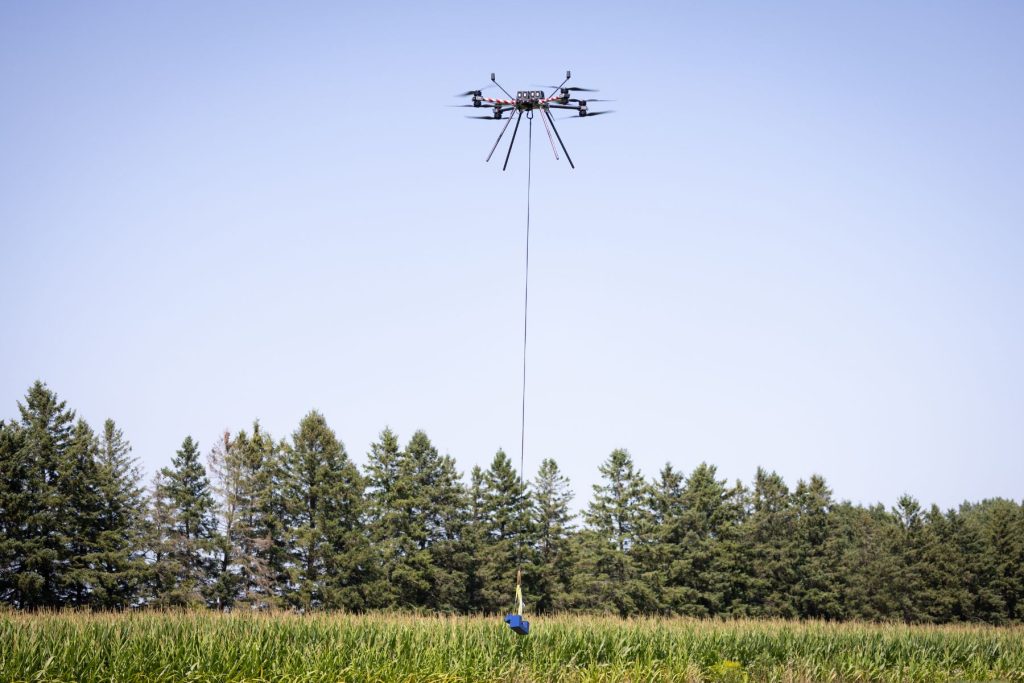 6 Drone hovering carrying payload in field