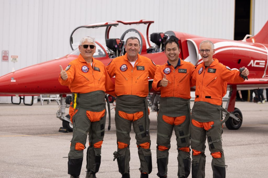 3 Giorgio Clementi, Stan Constantin, Bennett Leong, Alain Lacharite, all in orange flight suits in front of ACE aircraft