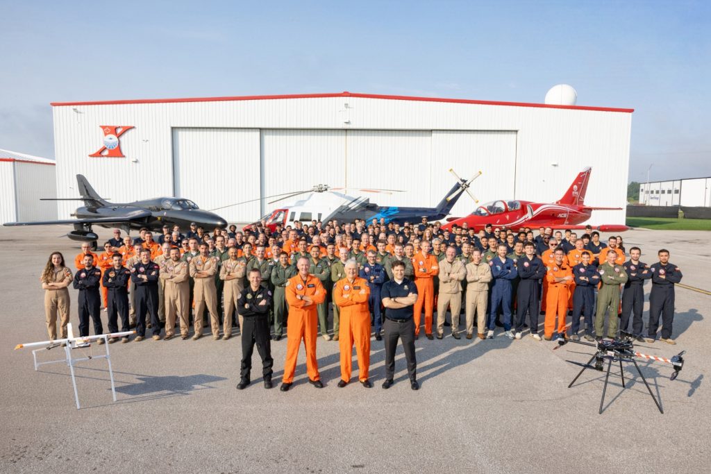 Everyone inc Bombardier (TurAF and ADF consent) 2026 ITPS staff and students in front of hangar with aircraft in background for school photo
